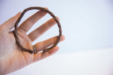 Vintage African twisted metal cuff bracelet held in a person's hand.