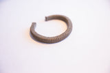 Profile of a vintage African cuff bracelet highlighting its ribbed texture and patina.