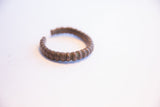 Side view of a vintage African cuff showing its segmented design and oxidized patina.