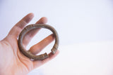 Vintage African oxidized cuff bracelet held in hand to demonstrate scale and texture.