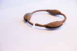 The open ends and rustic, textured surface of the vintage Yoruba rattle bracelet.
