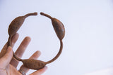 Vintage Yoruba dance rattle bracelet held, displaying its open circular form and rustic patina.