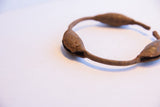Close-up view of the rich, textured patina on a handmade Yoruba rattle bracelet.