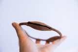 Side profile of a Yoruba rattle bracelet highlighting the slit and oxidized texture.