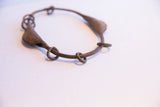 Aged, oxidized metalwork on a connecting ring of the vintage Yoruba bracelet.