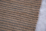 Textured weave of a handmade jute rug, with alternating natural beige and gray stripes.