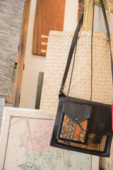 Dark pebbled leather flap pocket over vintage orange and blue rug fragment shoulder bag.