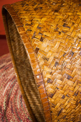 Distinctive diagonal weave and golden bamboo texture of the antique basket rim.