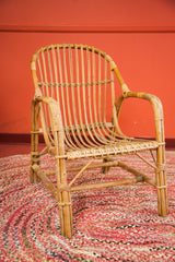 Right side close-up of a Mid Century Modern rattan chair's woven armrest and seat.