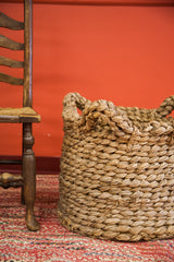 Vintage basket's intricate braided handles and nubby woven texture.