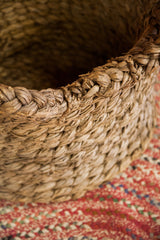 Intricate braided rim and nubby woven texture of the vintage basket.