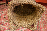 Braided rim and intricate handles of the vintage nubby basket's woven opening.