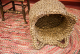 Vintage nubby basket with intricate braided detailing on its base and handles.