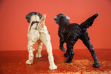 Rear view of two textured vintage pointer dog doorstops, beige and dark brown.