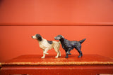 Vintage black and white and dark pointer dog doorstops displaying light paint chipping.