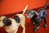 Chipping paint texture on vintage pointer dog doorstops, black and cream.