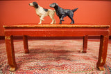 Vintage chippy red wicker coffee table with Parsons style legs.