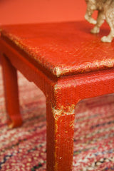 Chippy red painted wicker coffee table leg with exposed weave and wear.