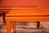 Vintage orange wicker table front, showing its woven texture and paint wear.