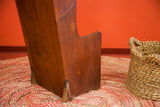 Antique settle chair's wide plank wooden leg showing bottom discoloration.