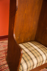 Antique Settle Chair's curved side, wide wood plank, and neutral plaid seat.
