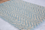 Close-up of Angelica jute rug with textured light blue and natural chevron weave.