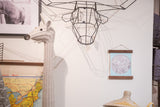 Light aqua moon chart print styled as wall art among eclectic and playful decor pieces.