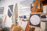 Black and white moon chart art hanging with walnut wood rods.