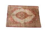 Antique Haji Jalili Tabriz silk mat with a rust and green medallion on an open ivory field.