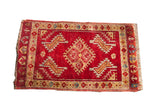 Vintage Turkish rug with deep red field, geometric medallion, and blue, yellow, beige details.