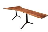 Handcrafted live edge redwood dining table with rich wood grain and black forged iron tripod legs.
