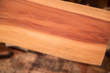Detail of the natural reddish wood grain on a live edge redwood table surface.