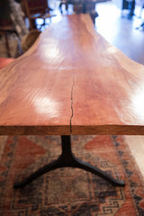 A natural wood split on the redwood table's end, highlighting the iron base below.