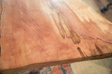 Rich, warm wood grain and natural figuring on the surface of a live edge redwood table.