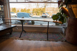 Full side view of the XL live edge redwood table on hand-forged iron legs.