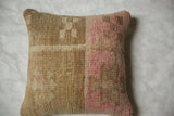 Vintage Oushak rug fragment pillow with textured beige and faded pink blocks, showing wear.