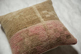 Textured pile showing distressed beige and muted pink bands on a vintage Oushak pillow.
