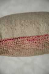 Textured vintage Oushak fragment pillow pile with vibrant pink threads.