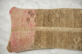 Close-up of distressed pink and beige vintage rug fragment texture.