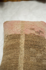Distressed woven texture and muted pink, brown, beige tones of Oushak rug pillow.