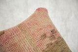 Distressed hand-knotted texture of vintage Oushak pillow in soft pink and beige.