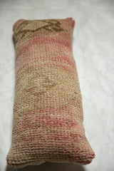 Variegated faded rose and natural tones on the textured hand-knotted pile of the Oushak pillow.
