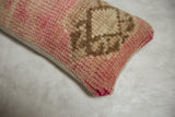 Textured corner of vintage Oushak fragment pillow, showing vibrant pink and beige pile.