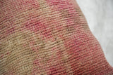Vintage Oushak rug fragment pillow's textured pile, blending pink and cream tones.