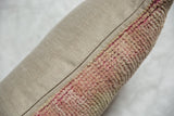 Textured pink vintage Oushak rug fragment side with smooth neutral fabric pillow backing.
