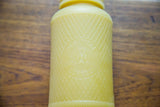 Embossed Old Judge Coffee owl with harlequin pattern on the vintage yellow bottle.