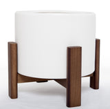 Angled view of the white ceramic pot in its brown wooden stand.