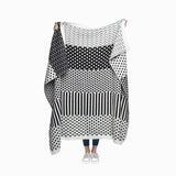 Modern black and white blanket with varied geometric patterns in bands.