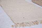 Visible hand-woven texture and fringe on a blanched jute rug.