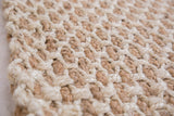 Chunky, hand-woven Charlette jute rug texture in alternating natural brown and light beige.